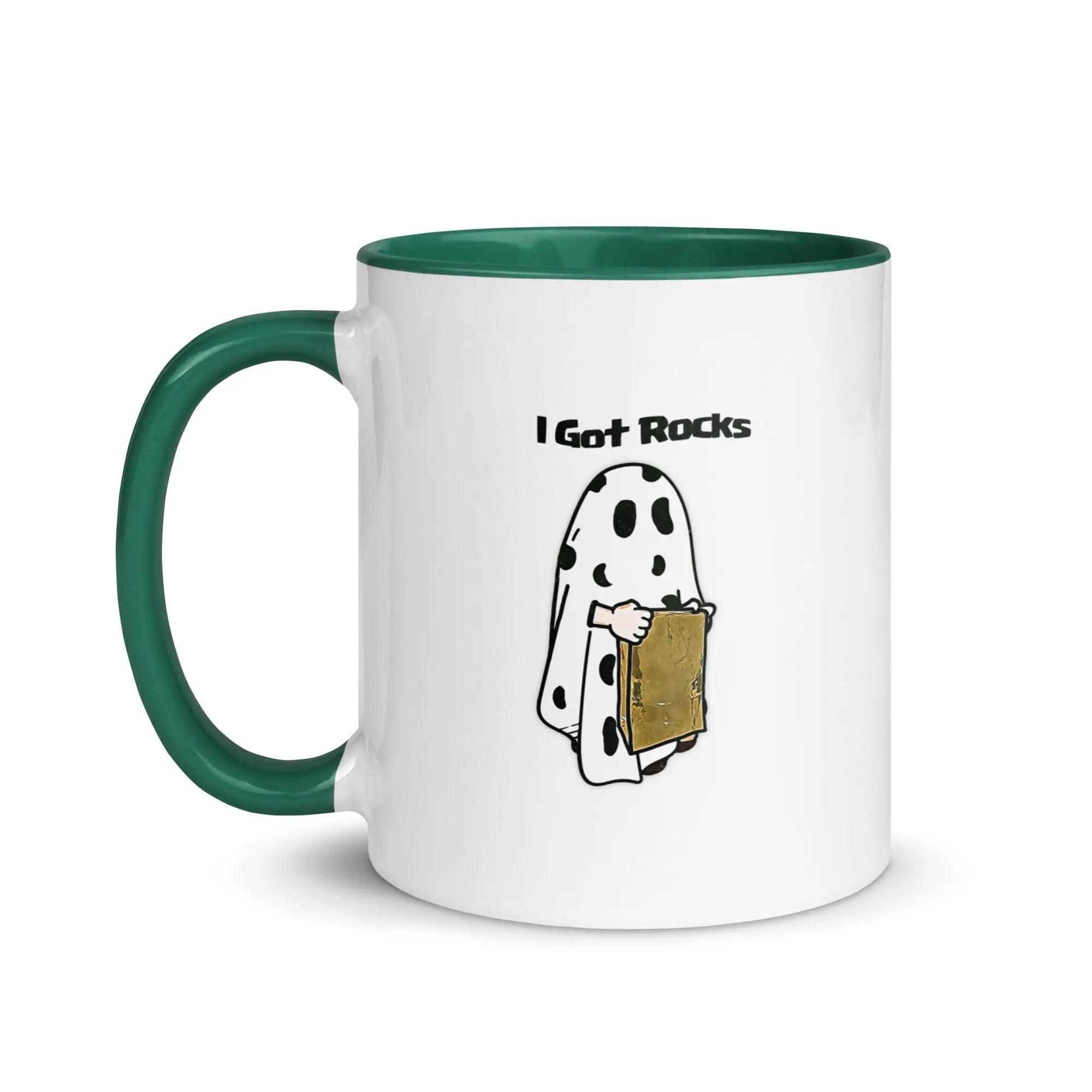 a white and green coffee mug with a cartoon of a ghost holding a piece of