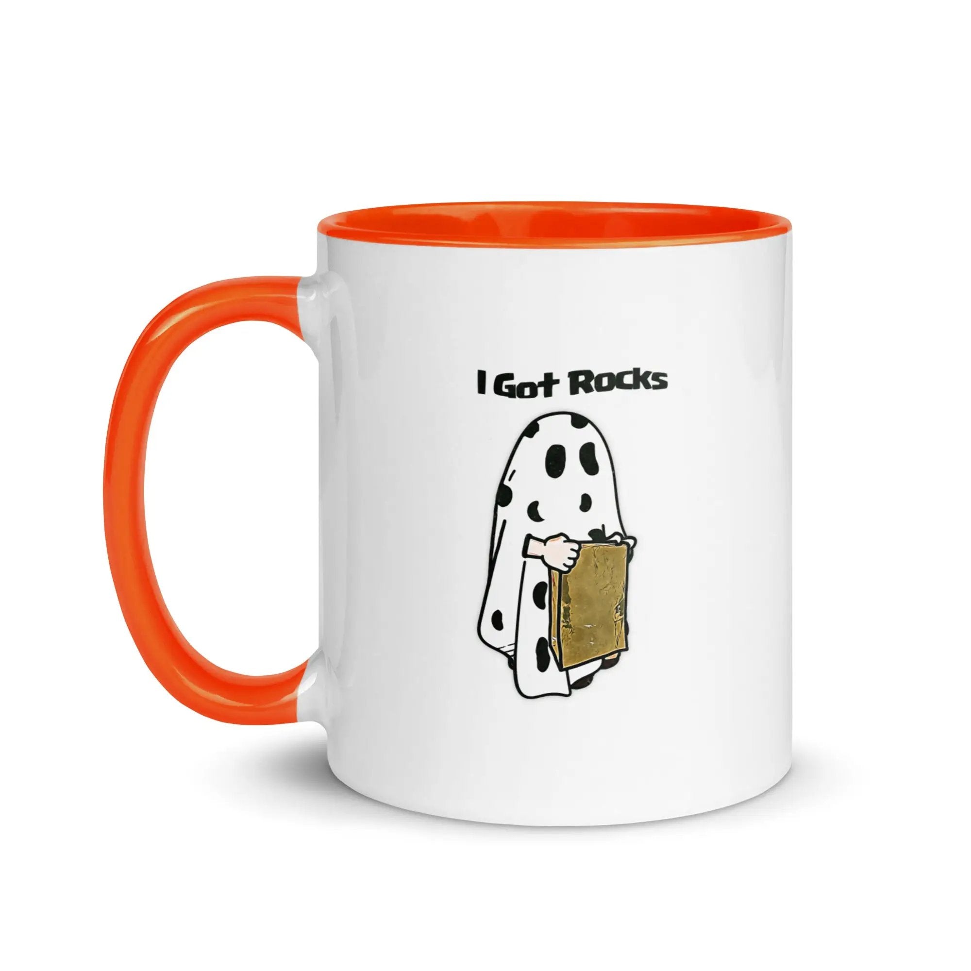 a white and orange coffee mug with a cartoon of a ghost holding a piece of
