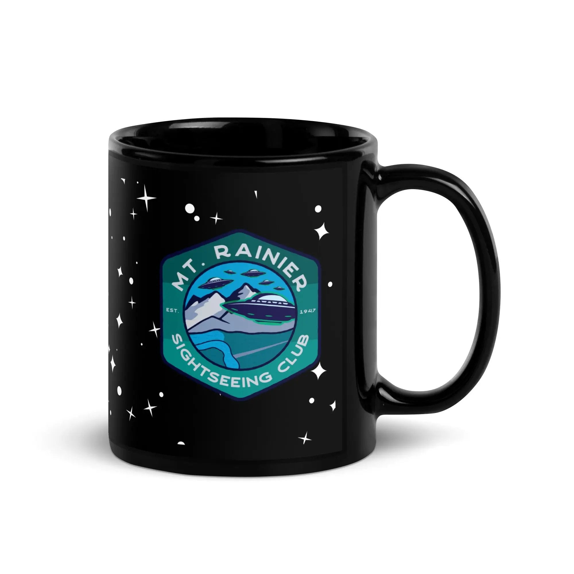 a black coffee mug with a mountain and stars on it