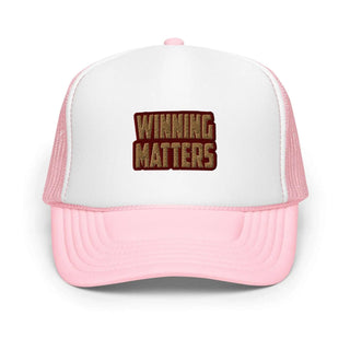 a pink and white trucker hat with the words winning matters on it