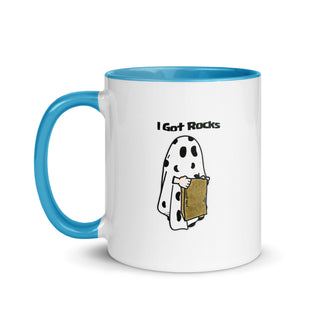 a blue and white coffee mug with a cartoon of a ghost holding a piece of
