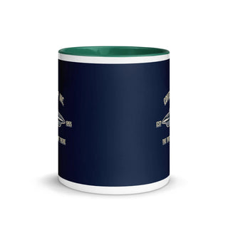 a blue and white coffee mug with a green rim