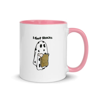 a white and pink coffee mug with a cartoon character holding a box